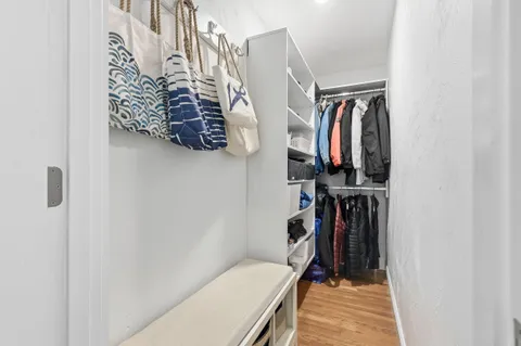 a view of walk in closet with clothes and shoes