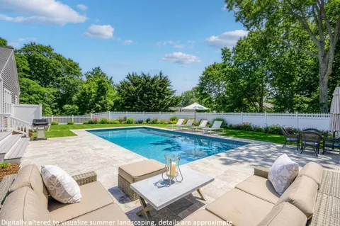 a view of swimming pool with seating space and trees in the background
