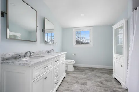 a bathroom with a granite countertop sink toilet and mirror