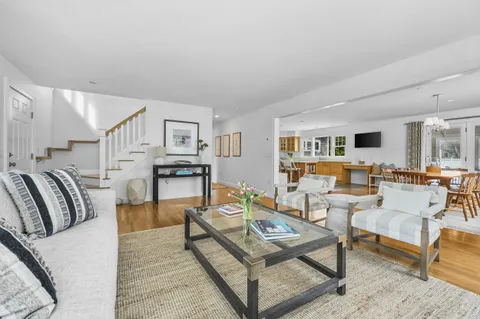 a living room with furniture kitchen view and a table