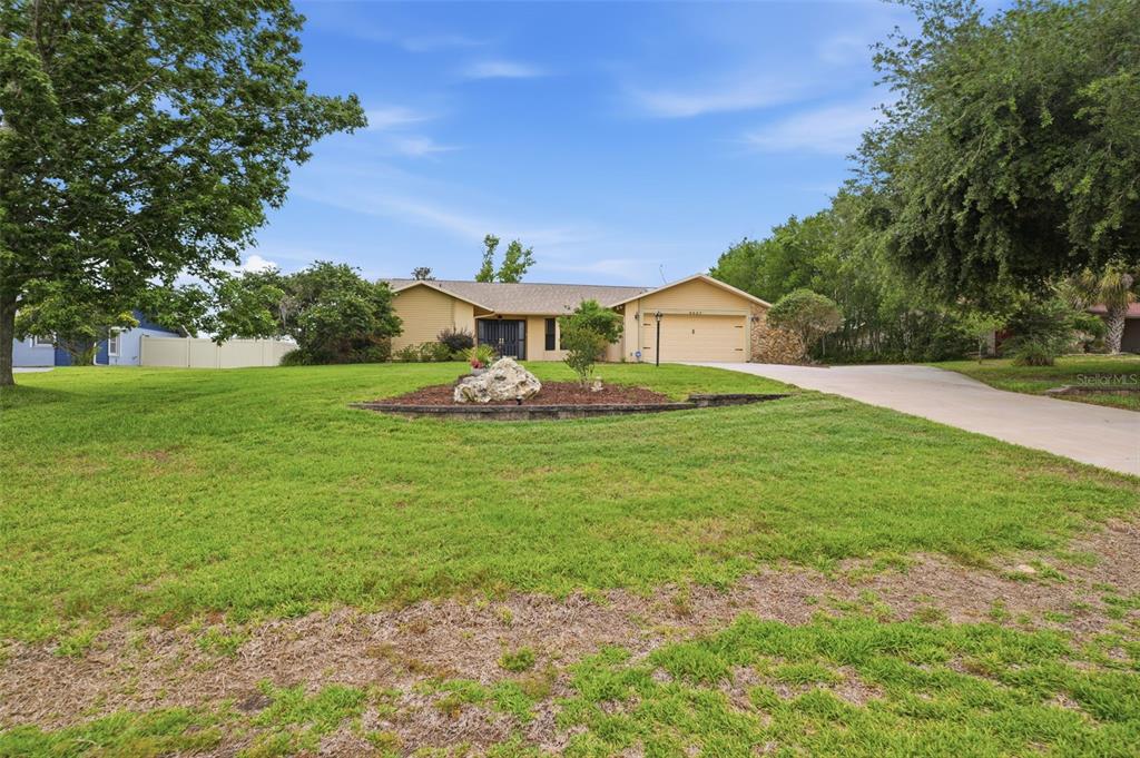 5227 Suwannee Road Weeki Wachee, FL 34607 - Photo 50 of 62 a front view of a house with garden
