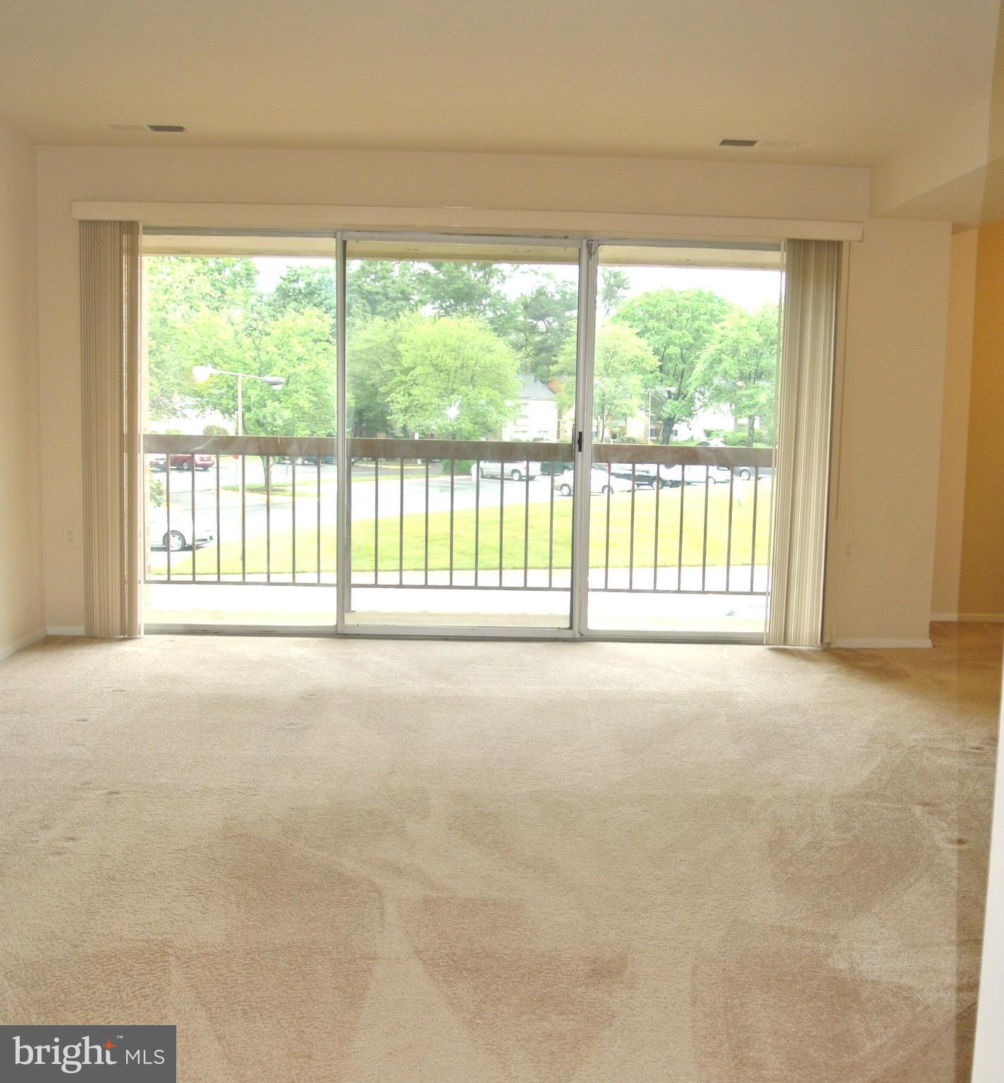 18712 Walkers Choice Road, Unit 4 Montgomery Village, MD 20886 - Photo 3 of 15 a view of an empty room with a floor to ceiling window and outside view