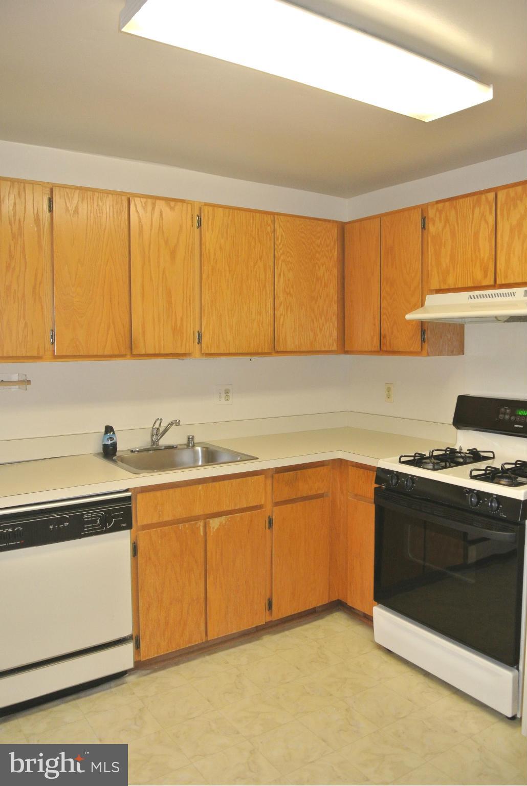 18712 Walkers Choice Road, Unit 4 Montgomery Village, MD 20886 - Photo 8 of 15 a kitchen with stainless steel appliances granite countertop a sink and a stove