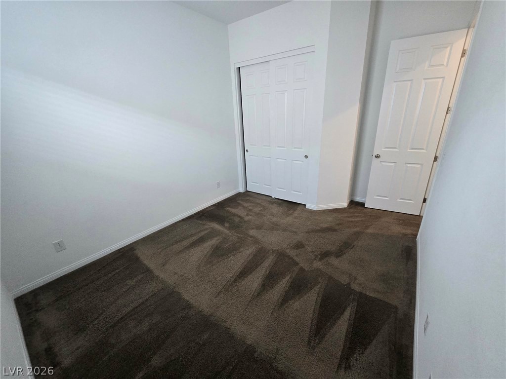 4748 Ritual Street North Las Vegas, NV 89031 - Photo 21 of 31 A well-maintained carpeted room offers ample closet space, ready for personalization.