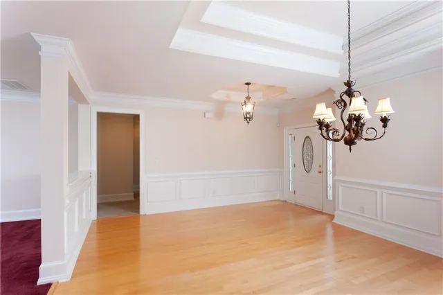 a view of an empty room with a chandelier fan