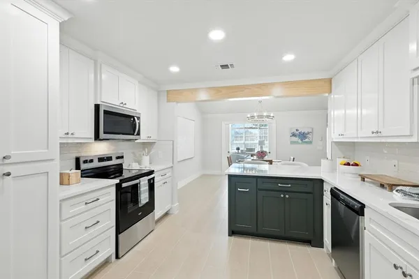 a kitchen with stainless steel appliances kitchen island granite countertop a sink and cabinets