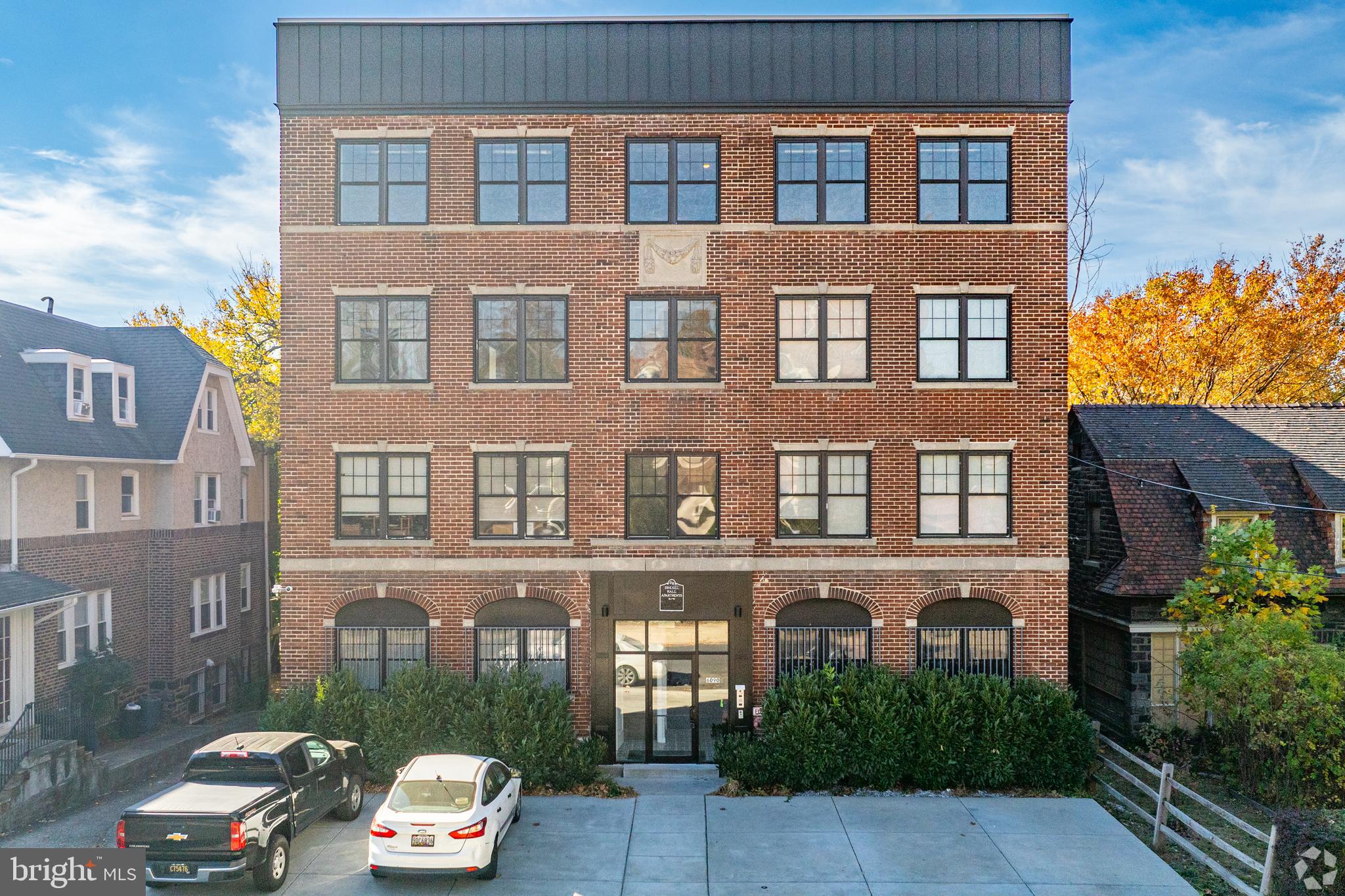 6090 Drexel Road, Unit 4 Philadelphia, PA 19131 - Photo 17 of 18 a front view of a building with a garden and parking space