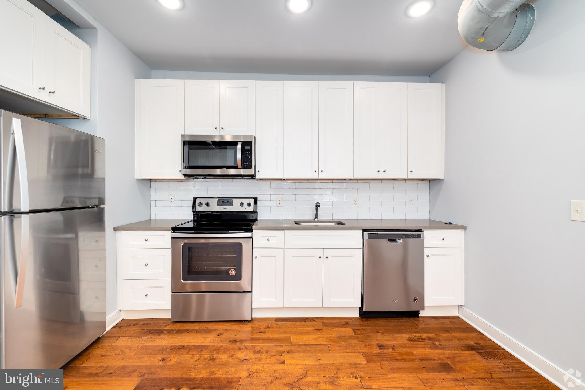 6090 Drexel Road, Unit 4 Philadelphia, PA 19131 - Photo 3 of 18 a kitchen with stainless steel appliances granite countertop a stove a refrigerator and a microwave