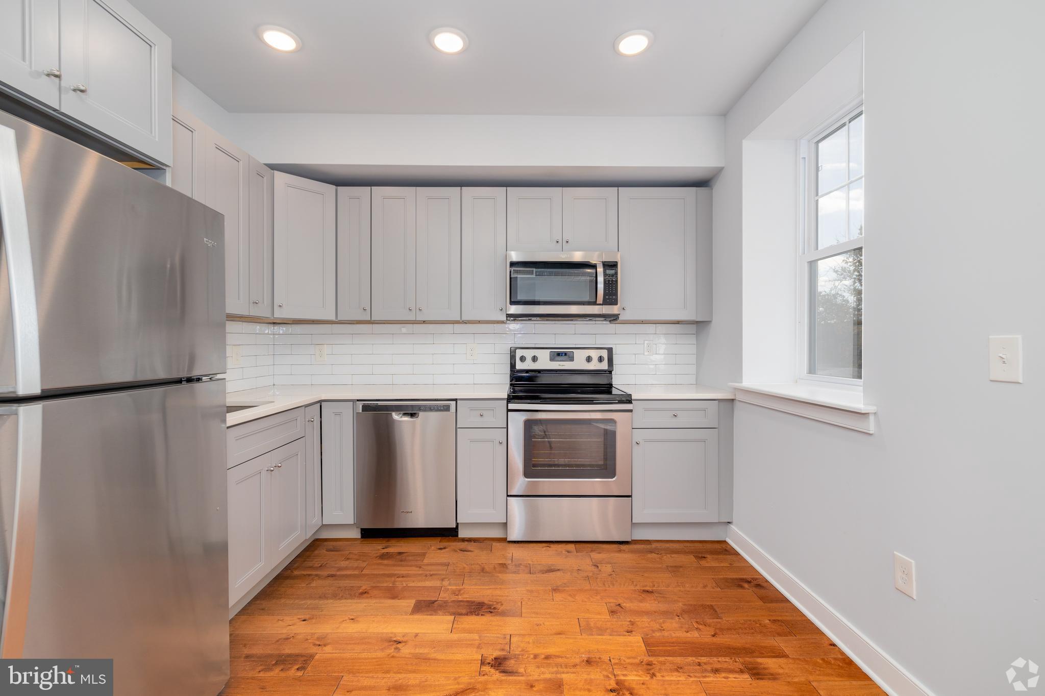 6090 Drexel Road, Unit 4 Philadelphia, PA 19131 - Photo 4 of 18 a kitchen with white cabinets and stainless steel appliances