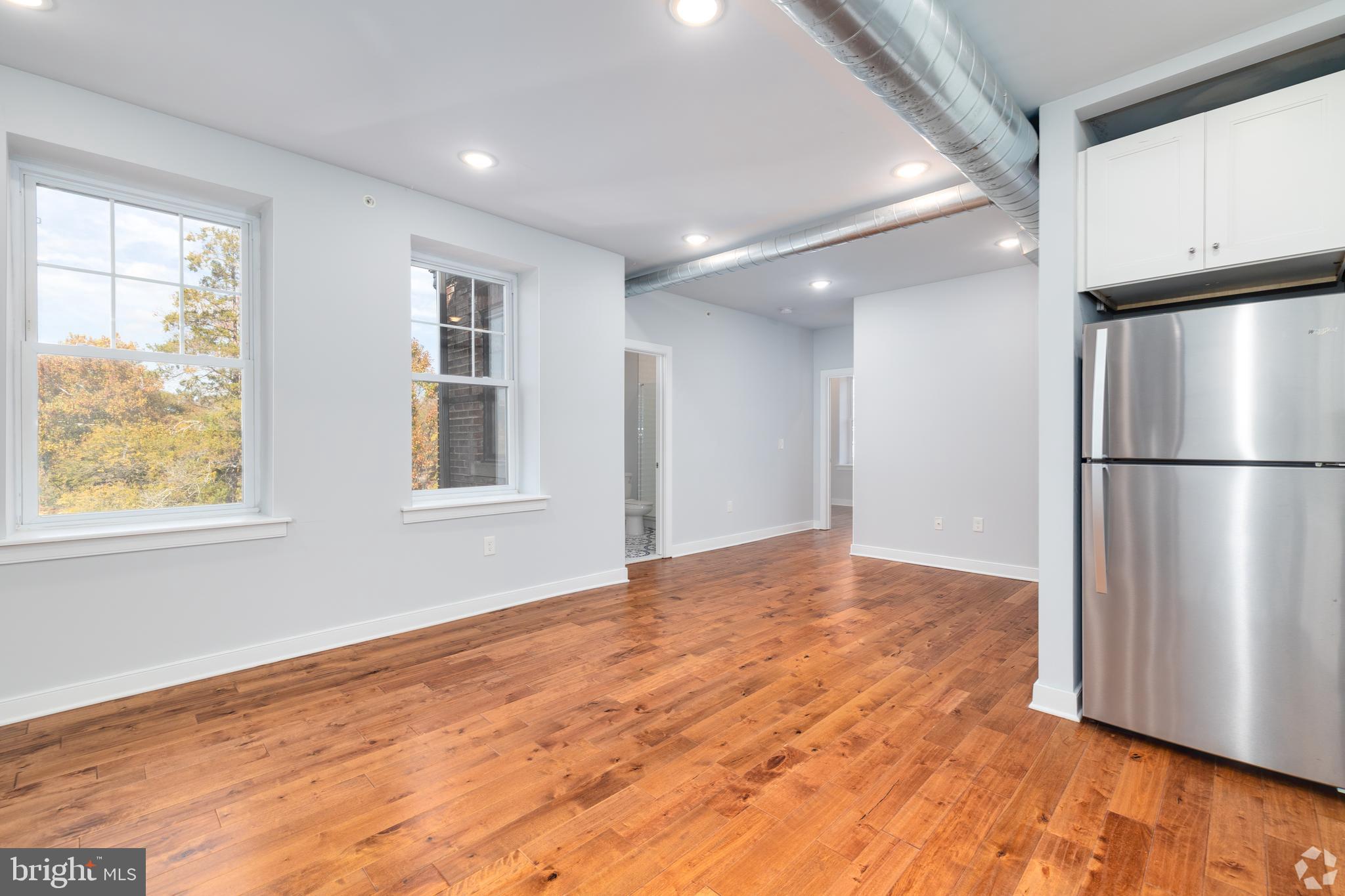 6090 Drexel Road, Unit 4 Philadelphia, PA 19131 - Photo 5 of 18 a view of an empty room with wooden floor and a window