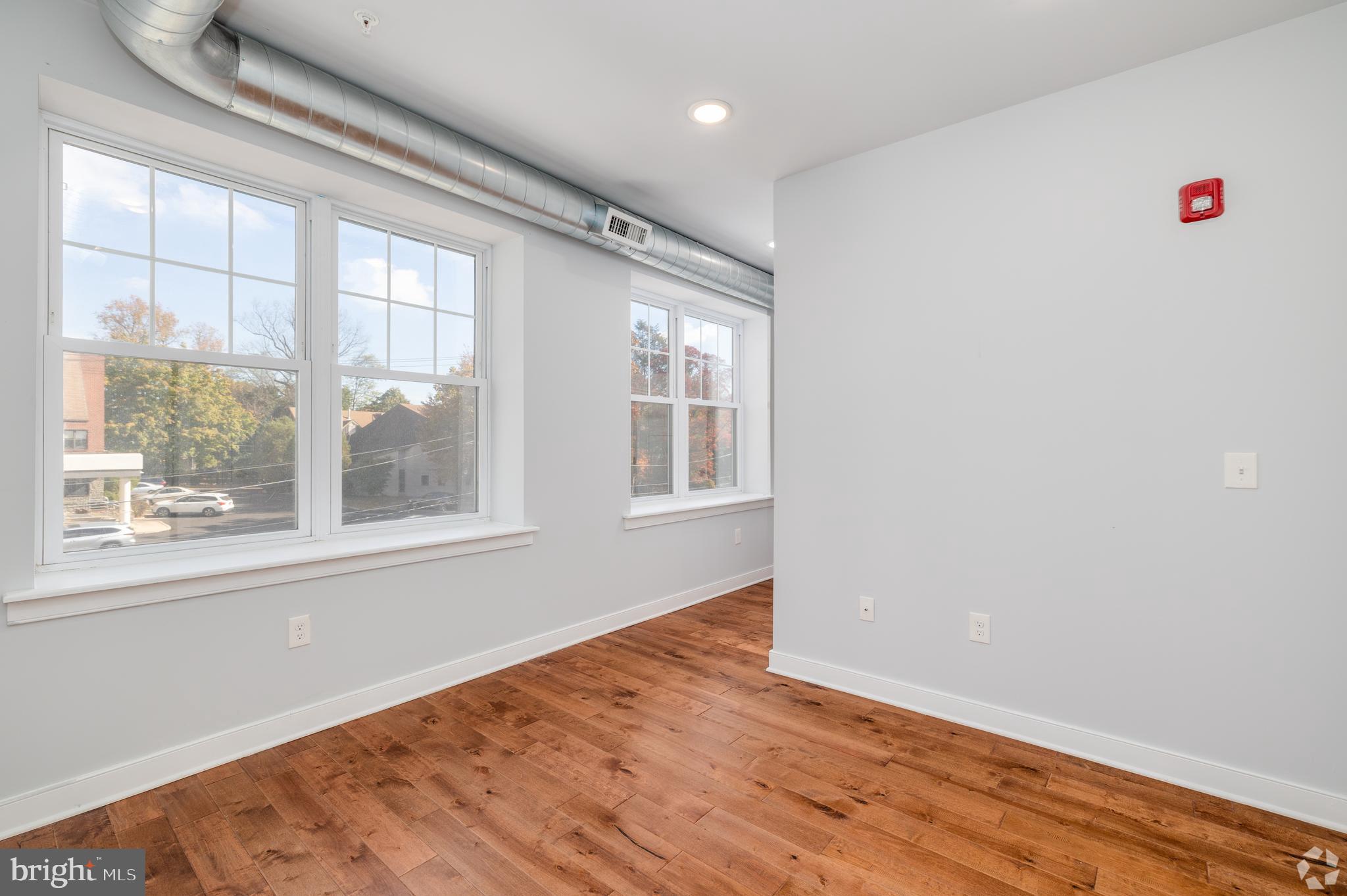 6090 Drexel Road, Unit 4 Philadelphia, PA 19131 - Photo 8 of 18 a view of an empty room with wooden floor and a window