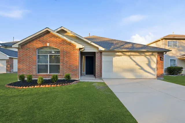 a front view of a house with a garden and yard