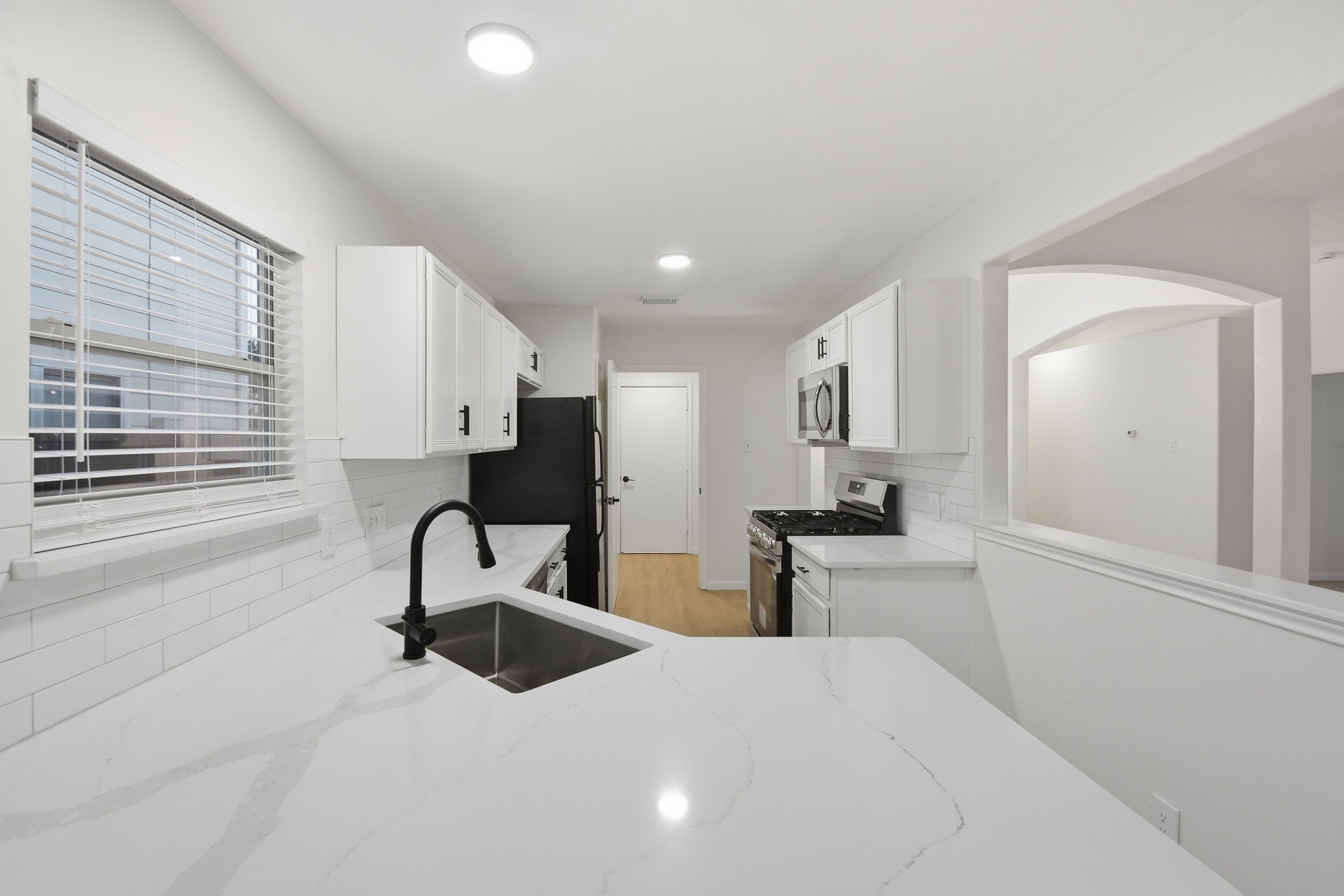 4426 Kulkarni Street Houston, TX 77045 - Photo 14 of 33 a kitchen with stainless steel appliances kitchen island sink refrigerator and stove