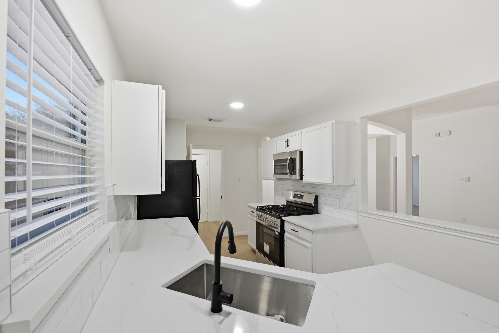 4426 Kulkarni Street Houston, TX 77045 - Photo 16 of 33 a kitchen with white cabinets and appliances