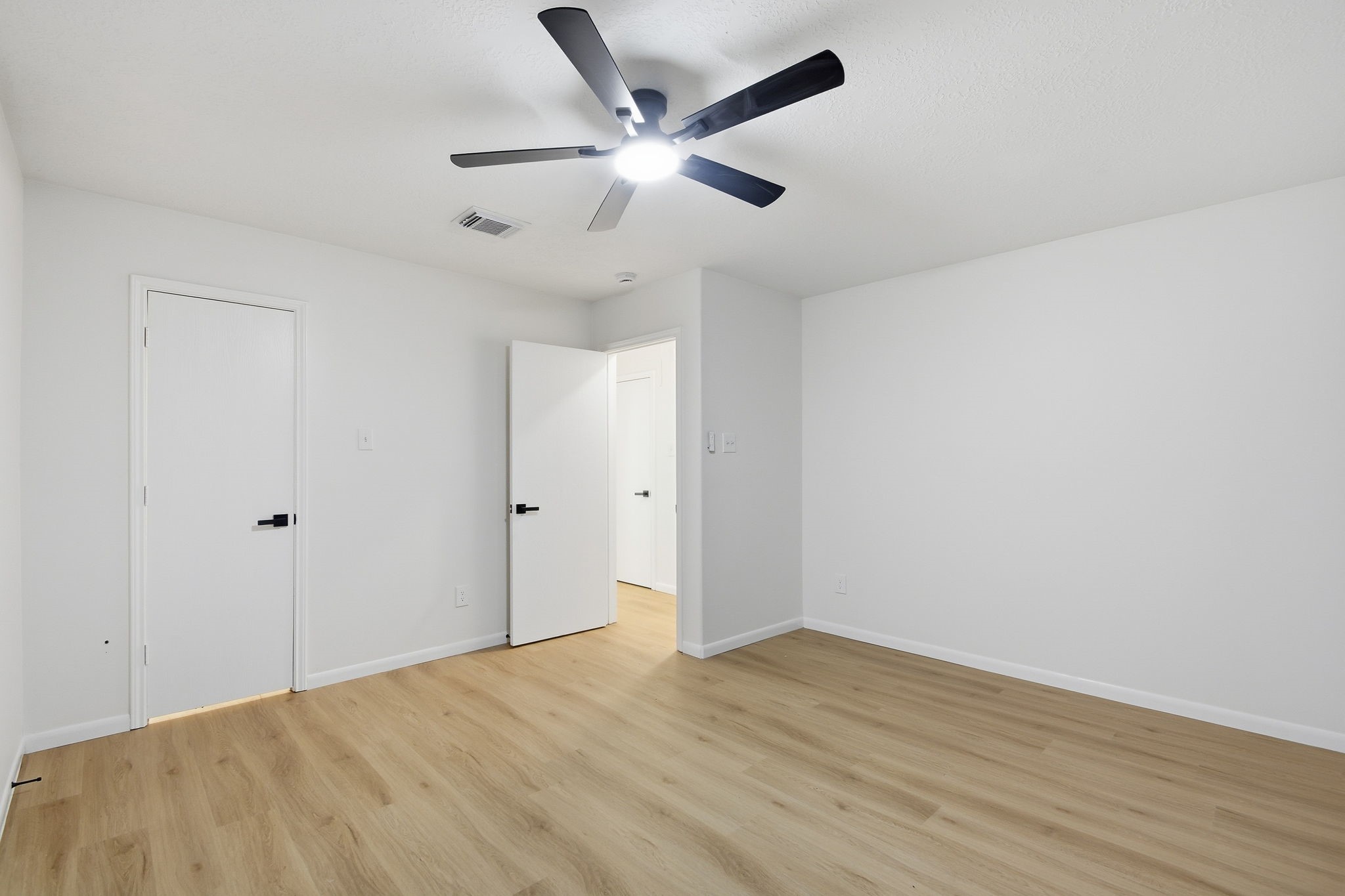 4426 Kulkarni Street Houston, TX 77045 - Photo 28 of 33 an empty room with wooden floor and ceiling fan