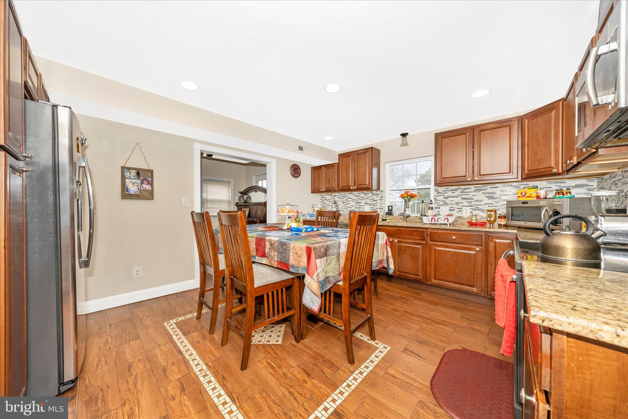9507 Main Street Damascus, MD 20872 - Photo 16 of 51 a dining room with stainless steel appliances granite countertop a dining table and chairs