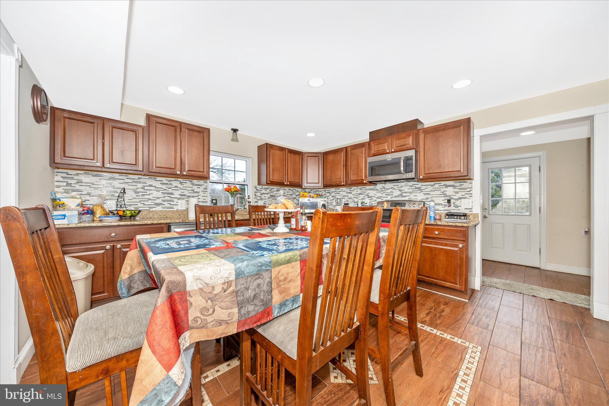 9507 Main Street Damascus, MD 20872 - Photo 18 of 51 a kitchen with stainless steel appliances kitchen island granite countertop a table and chairs