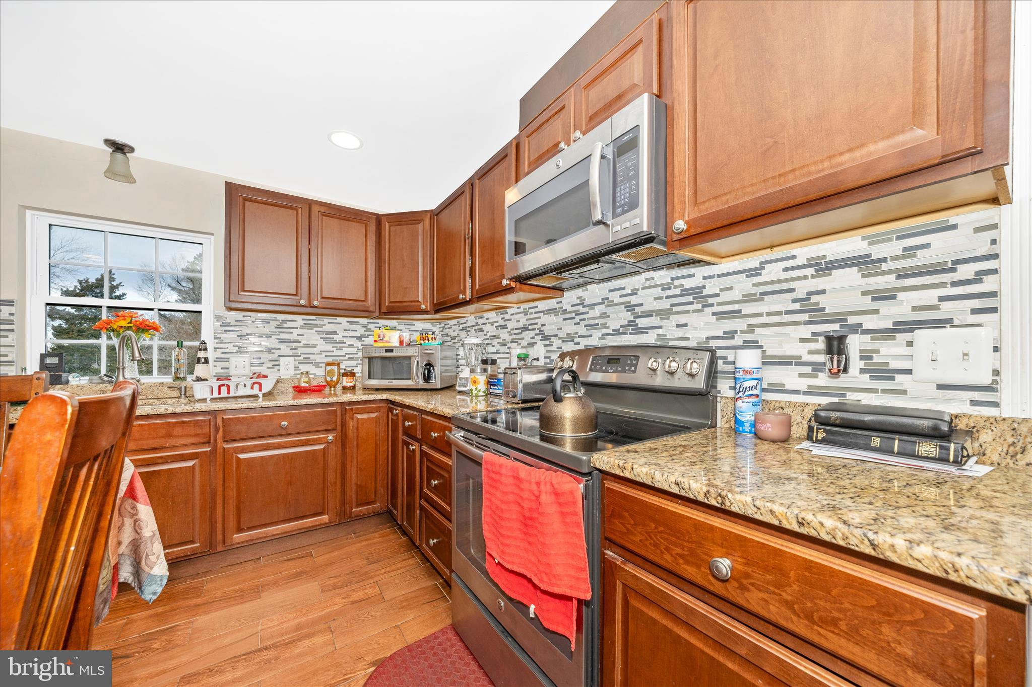 9507 Main Street Damascus, MD 20872 - Photo 19 of 51 a kitchen with stainless steel appliances granite countertop a sink stove and cabinets