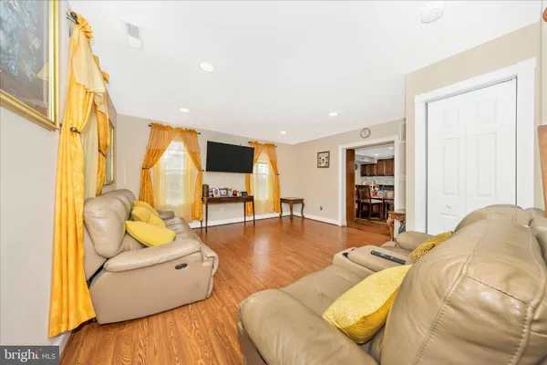 a living room with furniture and a table with wooden floor