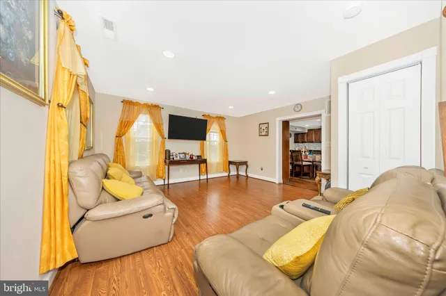 a living room with furniture and a table with wooden floor