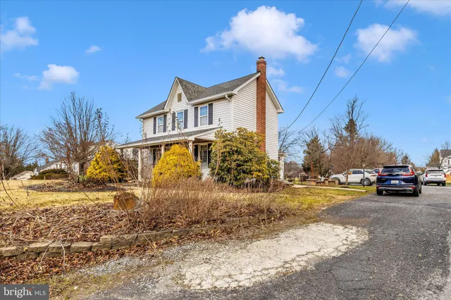 a view of a house with a yard and car parked