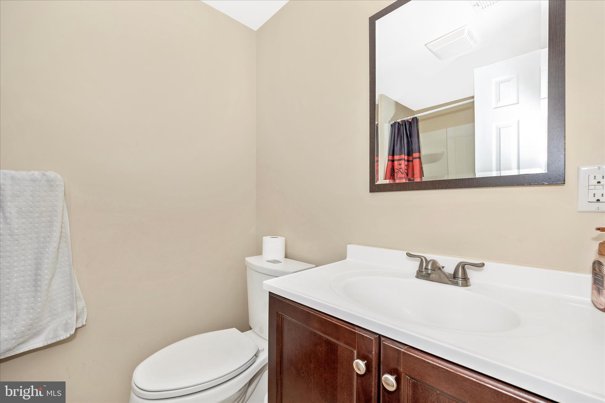 9507 Main Street Damascus, MD 20872 - Photo 40 of 51 a bathroom with a sink a toilet and mirror