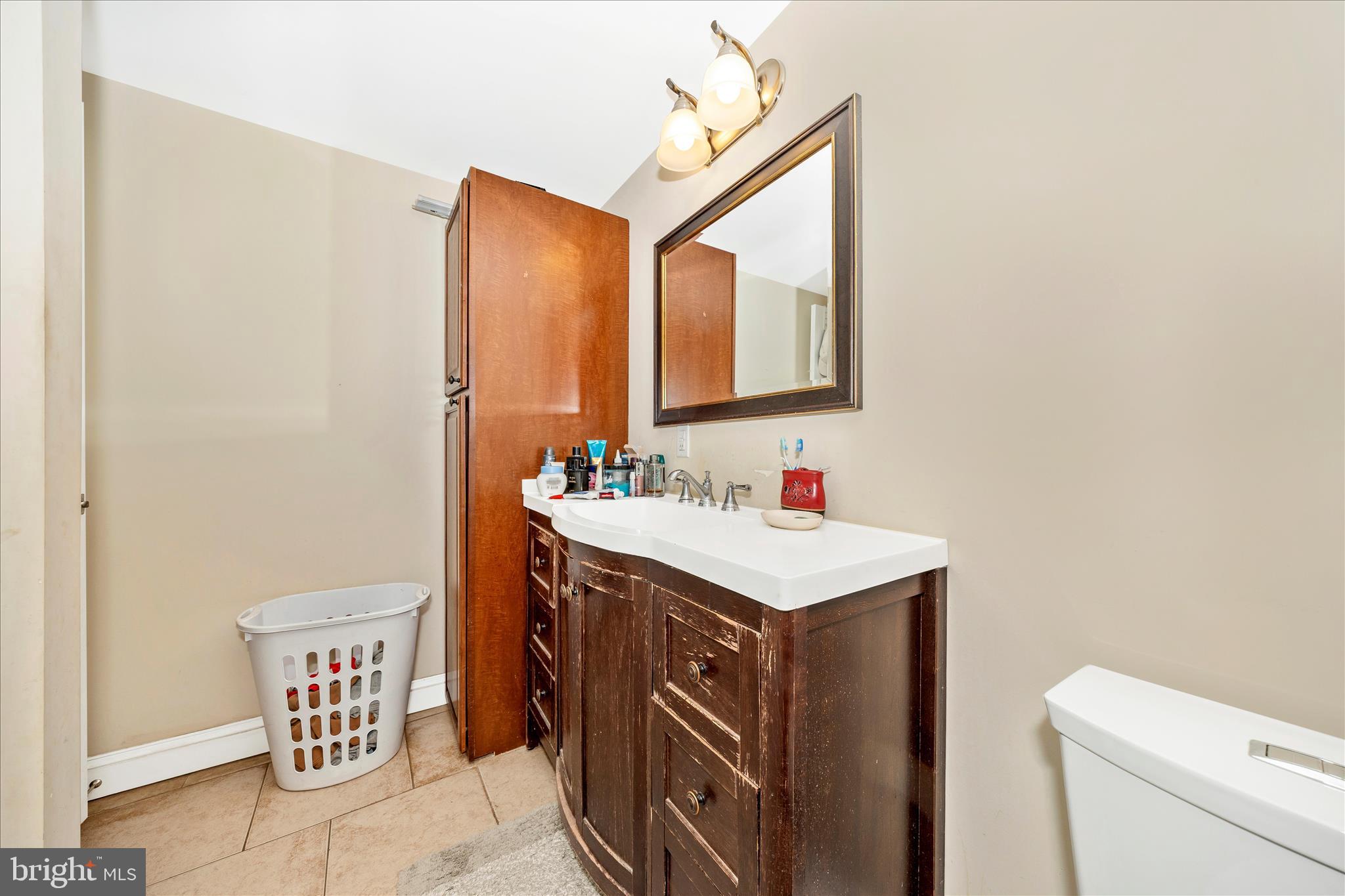 9507 Main Street Damascus, MD 20872 - Photo 47 of 51 a bathroom with a sink a toilet and mirror