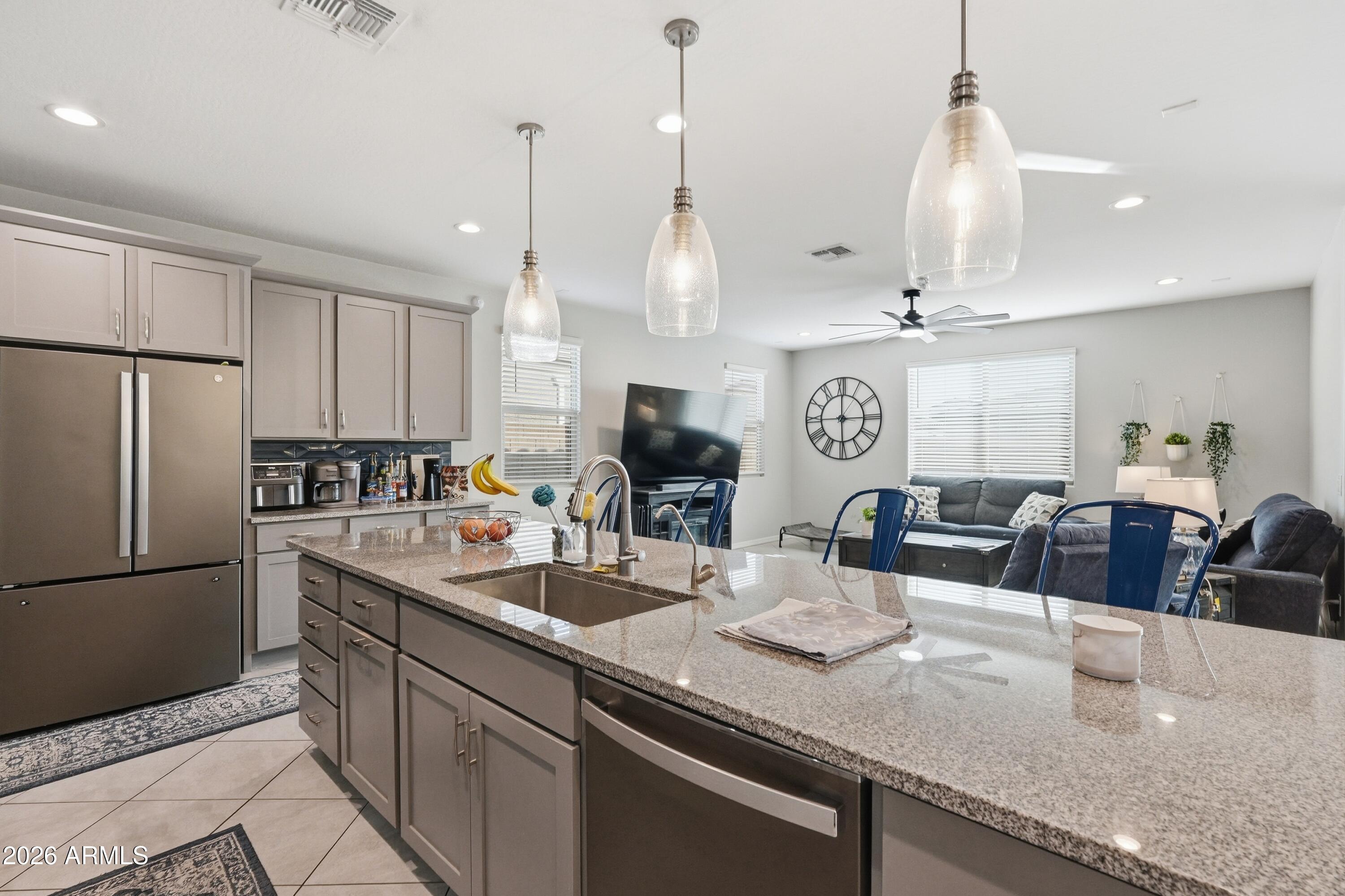 15727 West Madison Street Goodyear, AZ 85338 - Photo 14 of 41 a kitchen with stainless steel appliances granite countertop a sink a refrigerator and a white cabinets