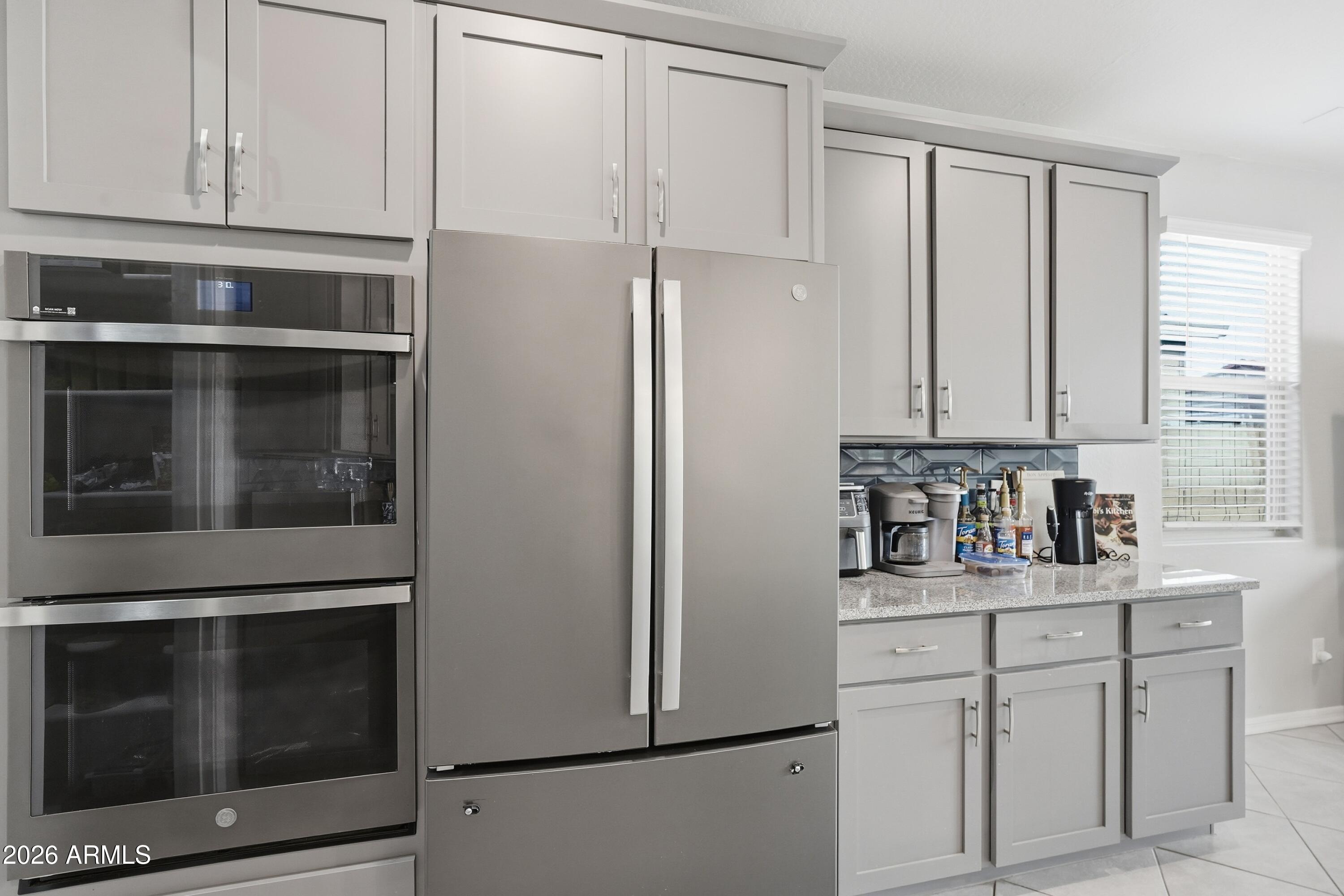 15727 West Madison Street Goodyear, AZ 85338 - Photo 17 of 41 a kitchen with stainless steel appliances white cabinets and a sink