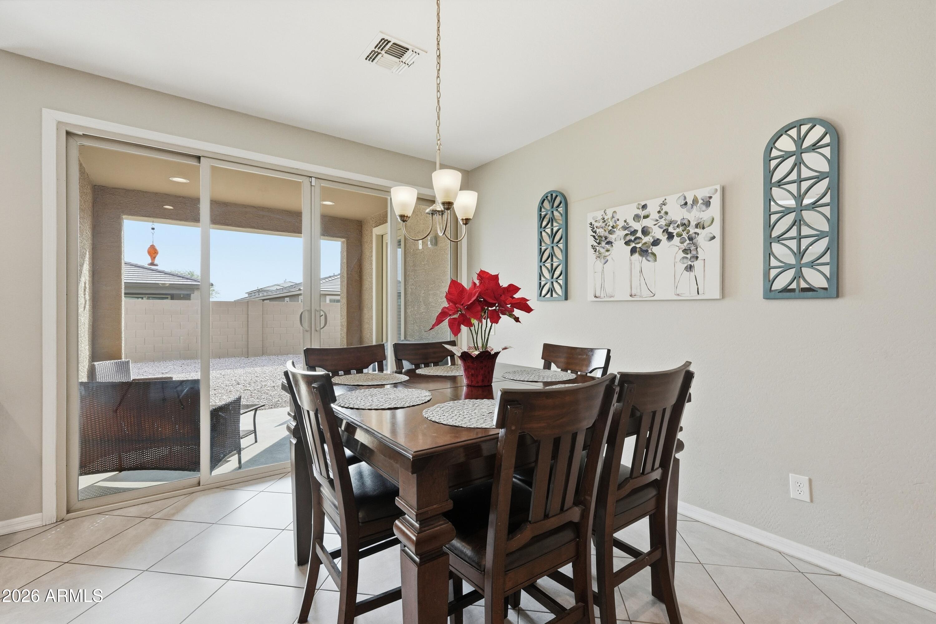 15727 West Madison Street Goodyear, AZ 85338 - Photo 18 of 41 a view of a dining room with furniture and chandelier