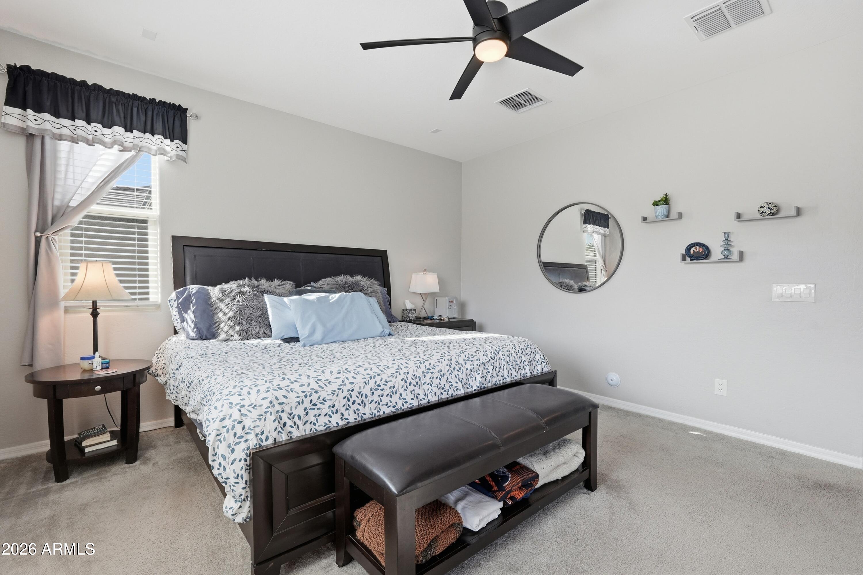 15727 West Madison Street Goodyear, AZ 85338 - Photo 22 of 41 a bedroom with a bed and a chandelier