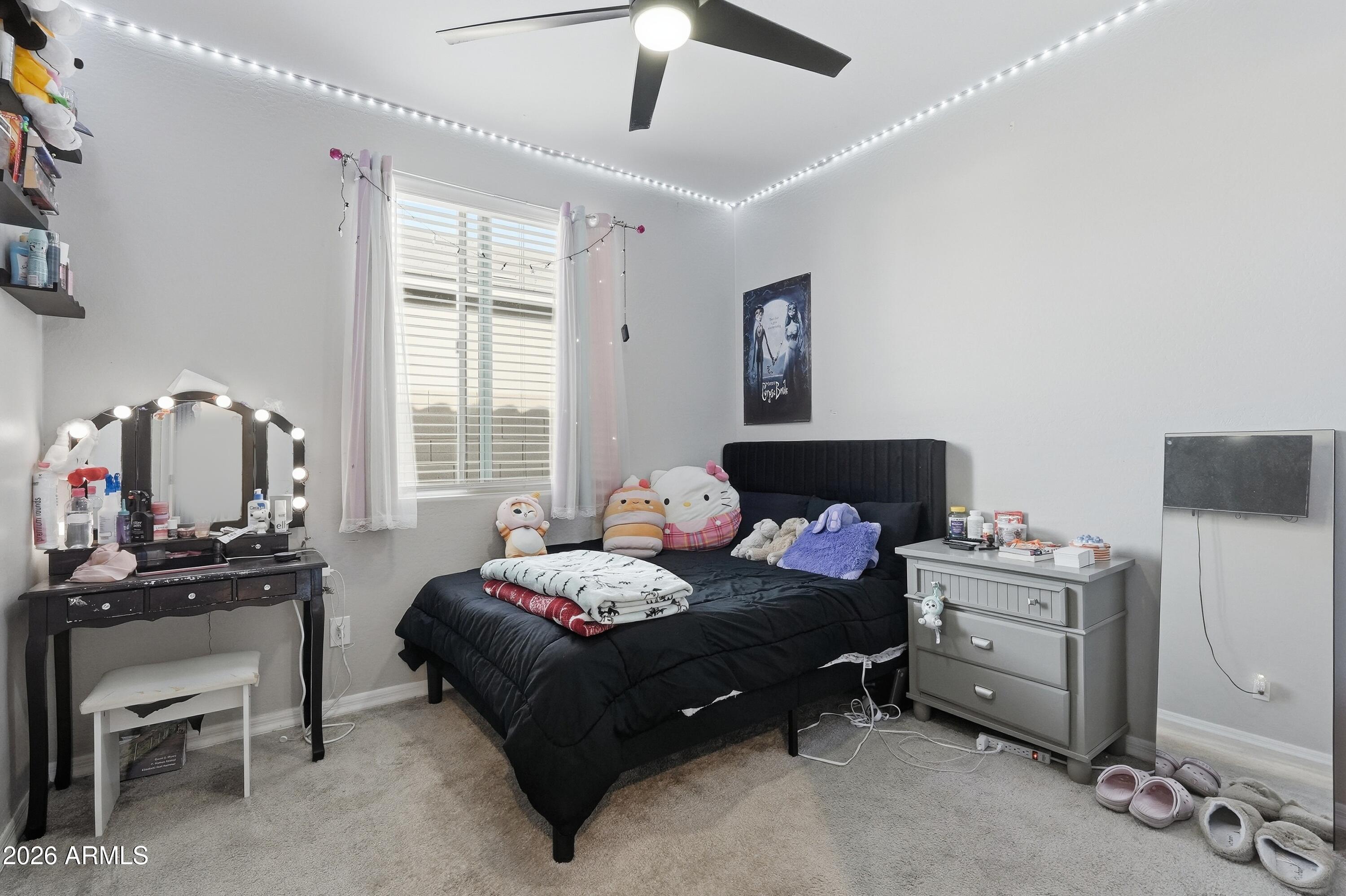 15727 West Madison Street Goodyear, AZ 85338 - Photo 25 of 41 a bedroom with a bed and a chandelier