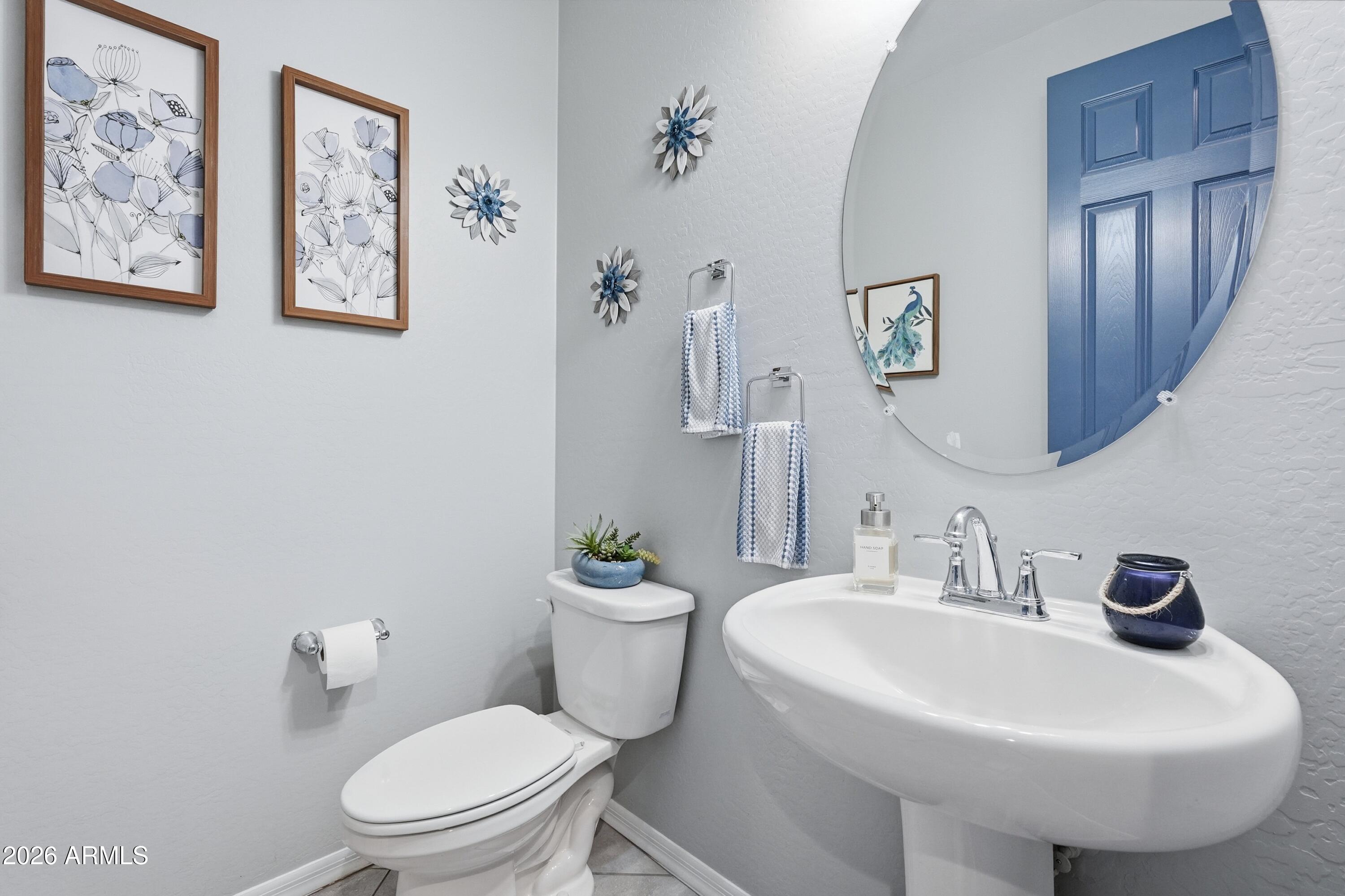 15727 West Madison Street Goodyear, AZ 85338 - Photo 31 of 41 a bathroom with a toilet sink and mirror