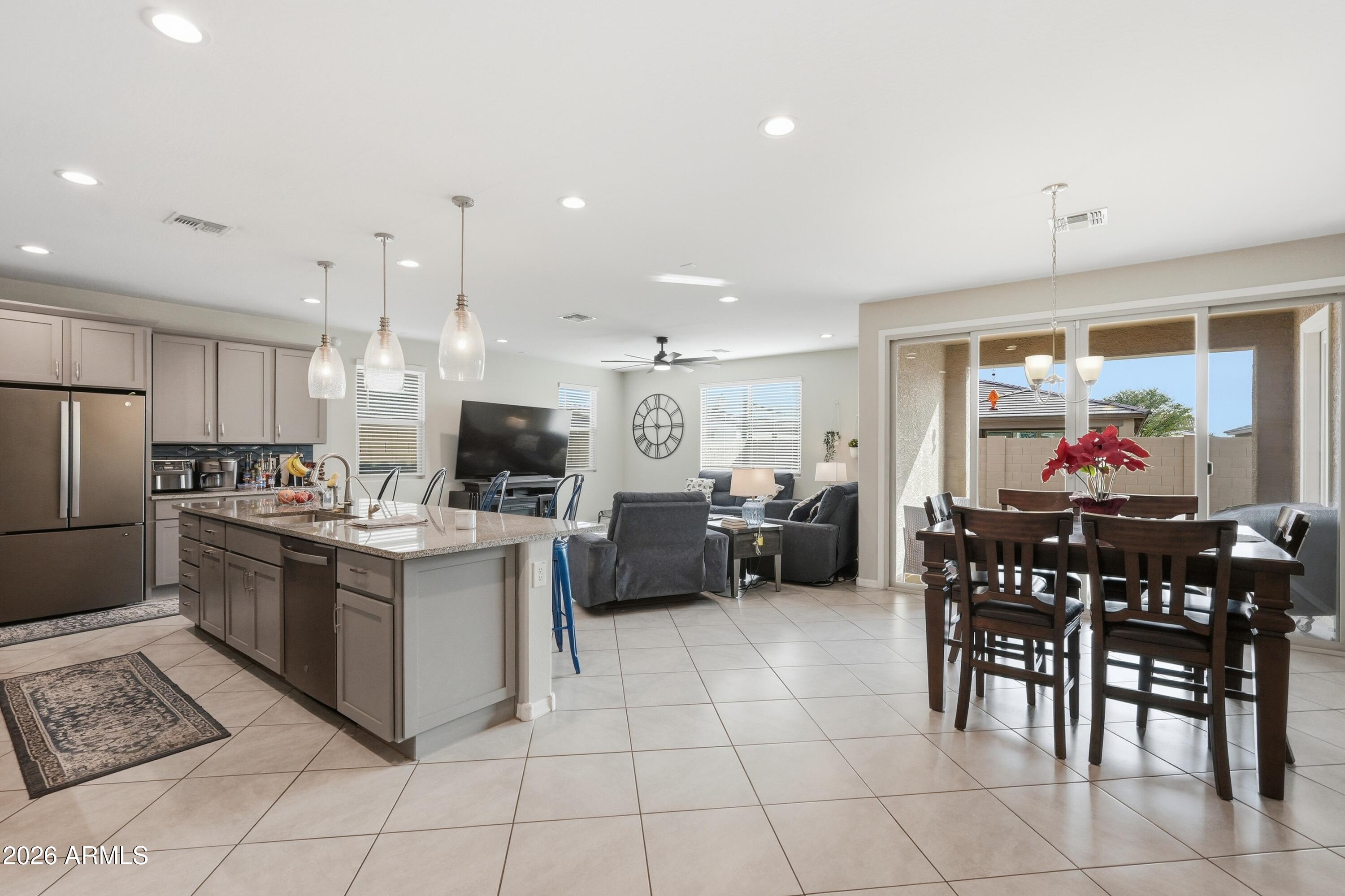 15727 West Madison Street Goodyear, AZ 85338 - Photo 7 of 41 a kitchen with stainless steel appliances kitchen island granite countertop a sink and cabinets