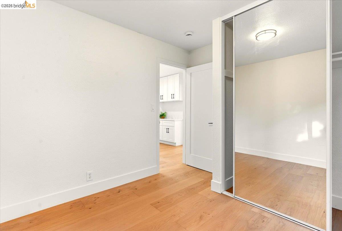 Unfurnished bedroom with baseboards and light wood-type flooring