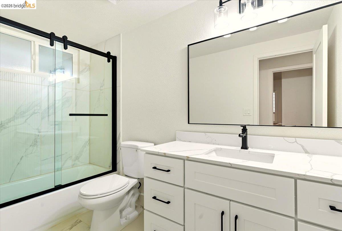 11 Paddock Court Pleasant Hill, CA 94523 - Photo 2 of 34 Full bathroom featuring vanity, combined bath / shower with glass door, and a textured wall
