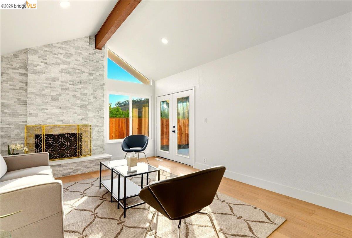 11 Paddock Court Pleasant Hill, CA 94523 - Photo 21 of 34 Living room with a fireplace, french doors, light wood-type flooring, beamed ceiling, and high vaulted ceiling