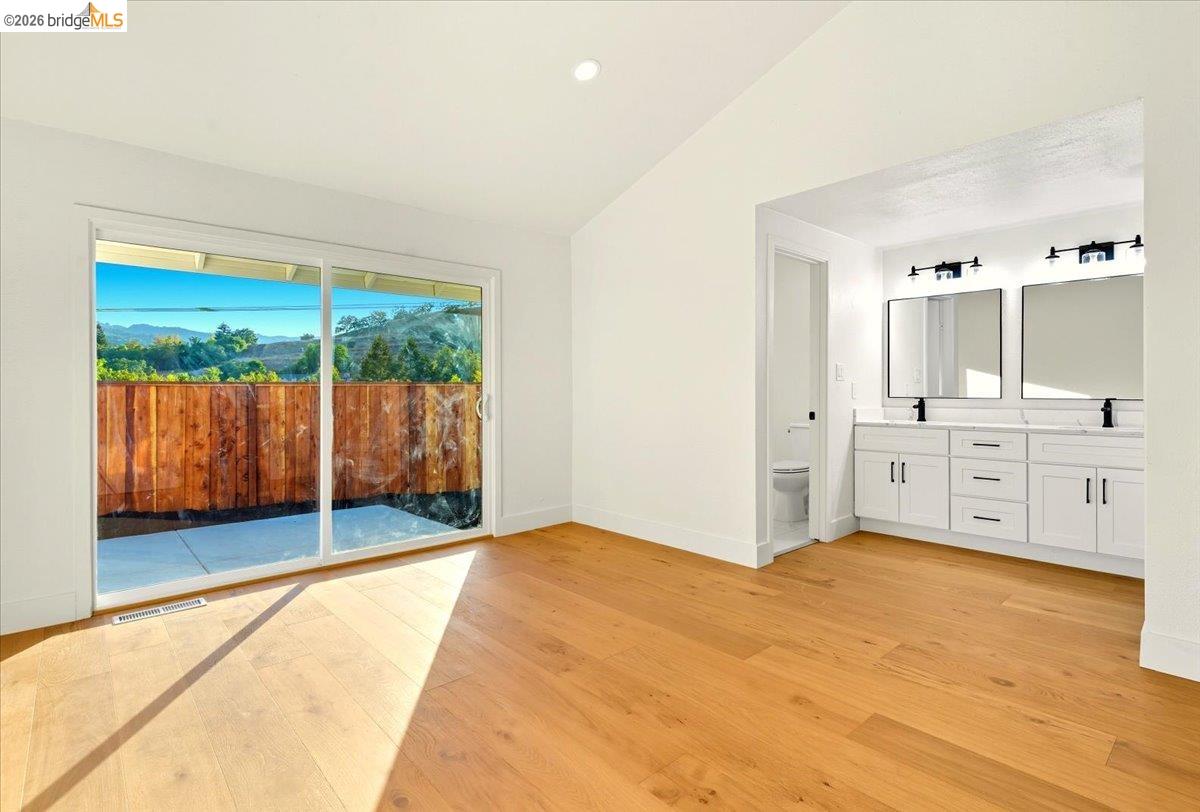 11 Paddock Court Pleasant Hill, CA 94523 - Photo 25 of 34 Empty room with vaulted ceiling and light wood-style floors