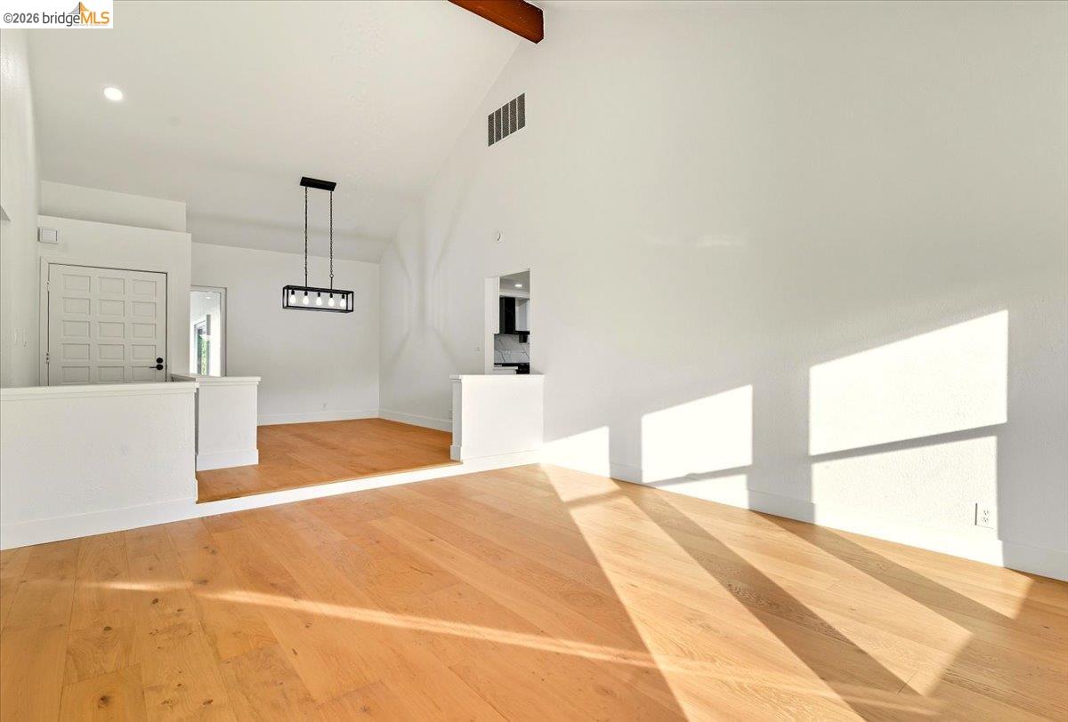11 Paddock Court Pleasant Hill, CA 94523 - Photo 7 of 34 Empty room featuring high vaulted ceiling, beamed ceiling, and light wood-type flooring