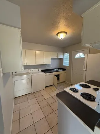a kitchen with granite countertop a sink a stove and cabinets
