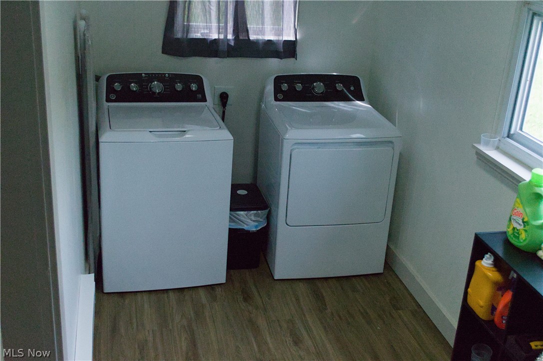 3187 Grenfall Road Barberton, OH 44203 - Photo 10 of 17 The property features a dedicated laundry area with a washer and dryer, a window with natural light, and wood-look flooring