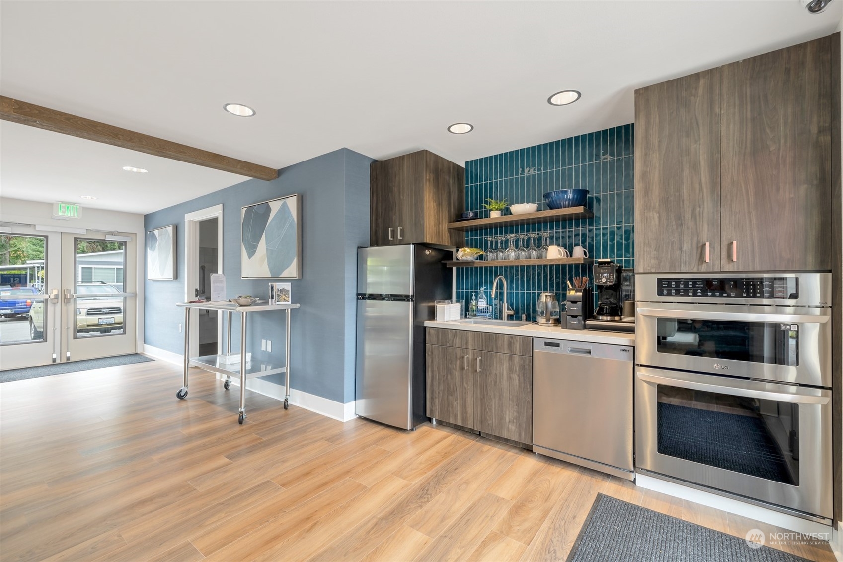 1121 244th Street Southwest, Unit 1 Bothell, WA 98021 - Photo 24 of 25 a kitchen with stainless steel appliances kitchen island granite countertop a refrigerator oven a sink dishwasher and white cabinets with wooden floor