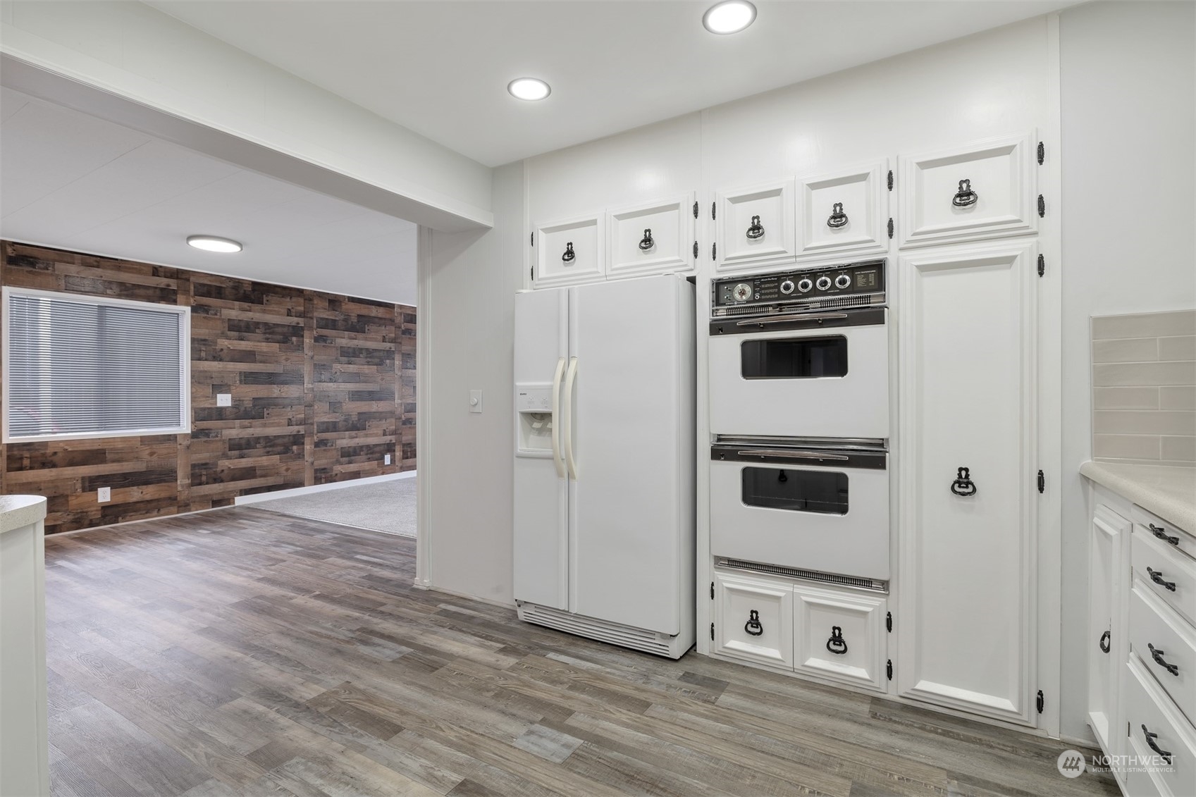 1121 244th Street Southwest, Unit 1 Bothell, WA 98021 - Photo 8 of 25 a view of kitchen with stainless steel appliances wooden floor and living room