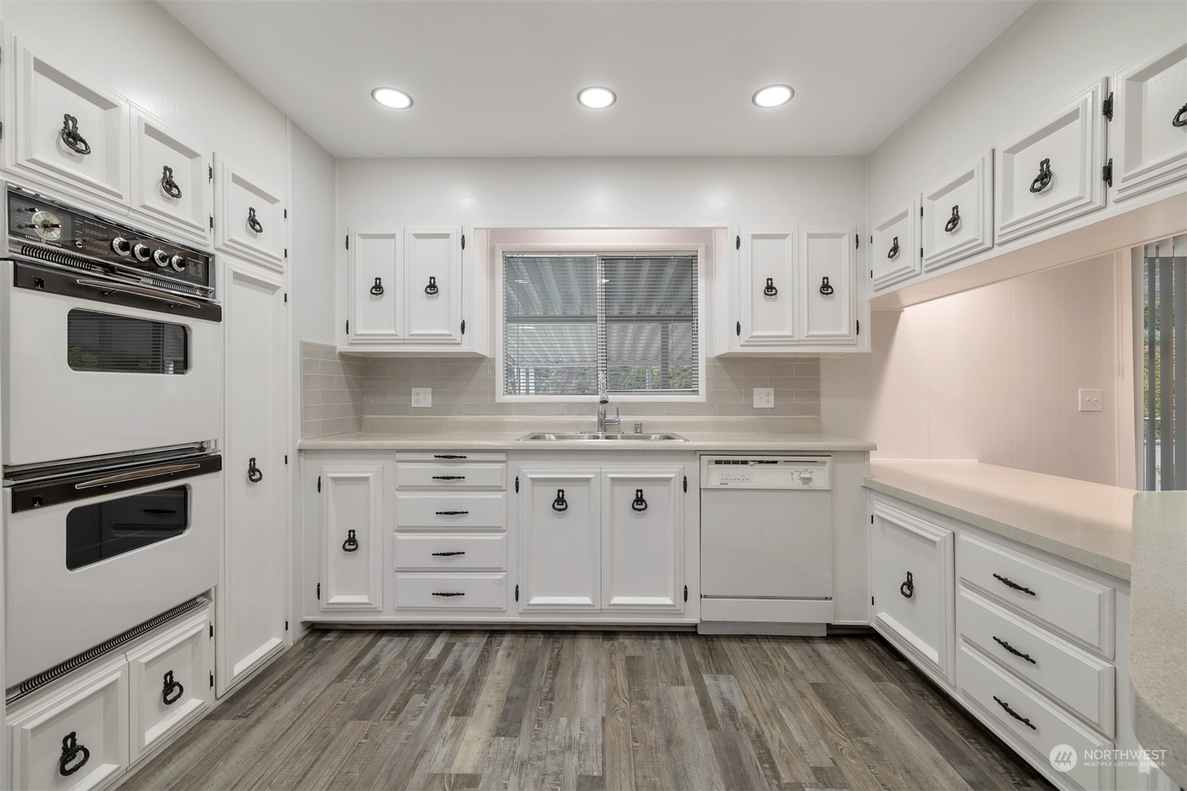 1121 244th Street Southwest, Unit 1 Bothell, WA 98021 - Photo 9 of 25 a kitchen with granite countertop white cabinets and white appliances