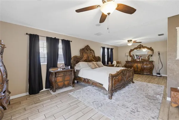 a bedroom with a large bed and a chandelier