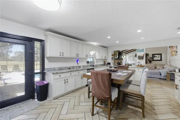 a kitchen with a dining table chairs and view living room