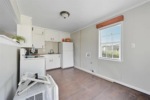 a room with white cabinets and white appliances