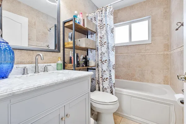 a bathroom with a granite countertop sink a toilet and bathtub