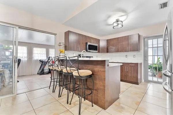 a kitchen with stainless steel appliances granite countertop a stove a sink a oven a dining table and chairs