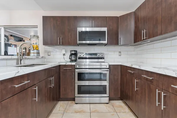 a kitchen with a sink stove and microwave